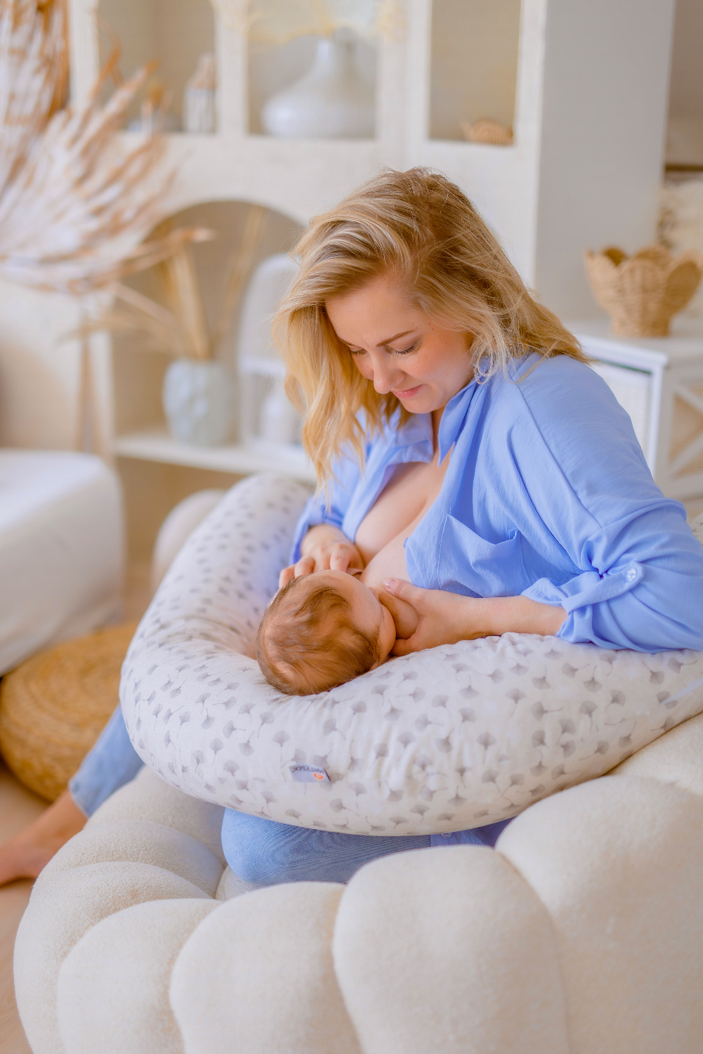 Maminka kojí miminko uložené na kojicím polštáři MAXI Matýsek ve správné výšce u prsu